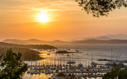 Scenic view of golden summer sunset over the island of Porquerolles in south of France with reflection to the Mediterranean sea